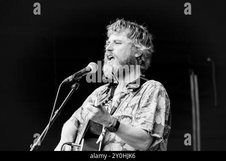 JOHNNY FLYNN, CONCERTO, 2024: Attore e cantante Johnny Flynn che suona a metà pomeriggio ambientato al sole estivo sul Mountain Stage. Secondo giorno del Green Man Festival 2024 al Glanusk Park, Brecon, Galles, il 16 agosto 2024. Foto: Rob Watkins. INFO: Johnny Flynn è un cantautore, musicista e attore britannico noto per il suo sound ispirato al folk. Mescolando folk tradizionale con indie rock, la sua musica presenta testi poetici e melodie acustiche. Anche lui attore di successo, Flynn bilancia la sua carriera musicale con ruoli notevoli nel cinema e nel teatro. Foto Stock