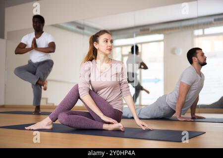 Donna seduta nel signore dei pesci posa, formazione di gruppo Foto Stock