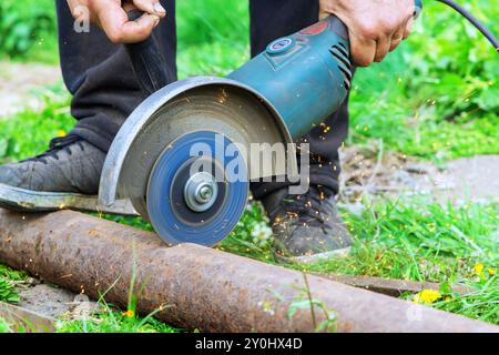 Quando si taglia il telaio in metallo, l'operatore utilizza una smerigliatrice angolare per tagliare il metallo Foto Stock