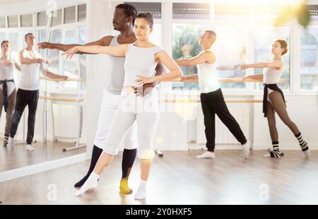 Ballerina dilettante di balletto che pratica con la partner in una classe di gruppo Foto Stock