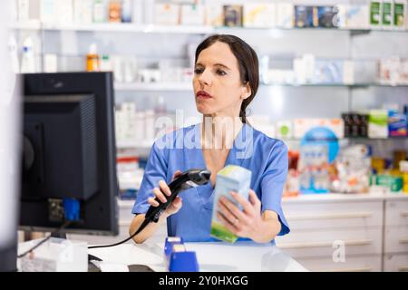 Ritratto di donna farmacista utilizzando il lettore di codici a barre su medicina Foto Stock