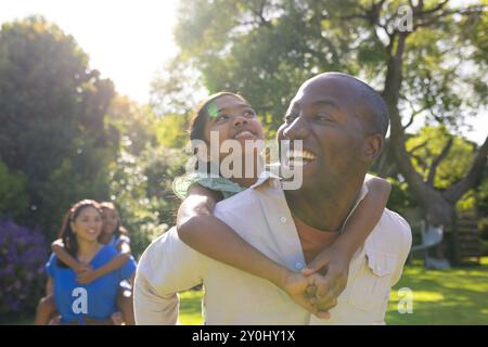 Regalando un giro in piggyback, padre e figlia sorridono, la famiglia si diverte all'aria aperta Foto Stock