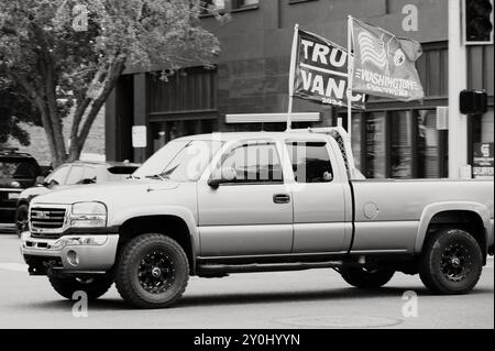 Un pick-up GMC di dimensioni standard che vola con le bandiere di Donald Trump e MAGA. Ellensburg, Washington, Stati Uniti. Immagine in bianco e nero. Foto Stock