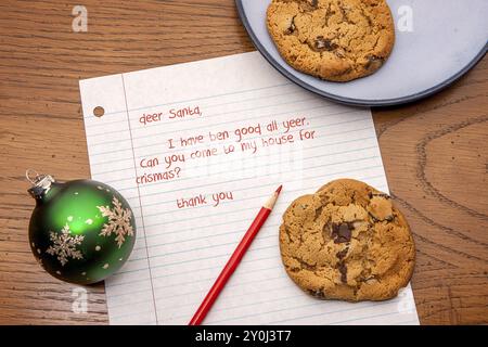 Un'immagine ravvicinata di una lettera a Babbo Natale, biscotti e alcune decorazioni Foto Stock