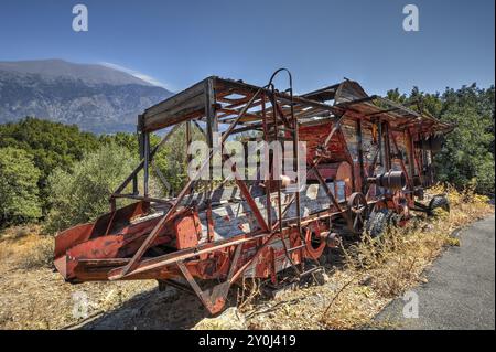 Vecchia mietitrebbia arrugginita in un paesaggio montano con cielo limpido, veicolo distrutto, Creta, Isole greche, Grecia, Europa Foto Stock