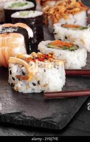 Sushi set primo piano con bacchette su sfondo nero Foto Stock