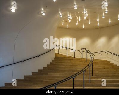 Scala curva in legno in un edificio con illuminazione moderna e pareti bianche, Amburgo, Germania, Europa Foto Stock