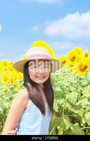 Ragazza che sorride nel campo di girasole Foto Stock