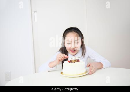 Ragazza che cerca di togliere le fragole da una torta Foto Stock