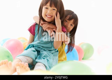 Sorelle gemelle che suonano con i balloni Foto Stock