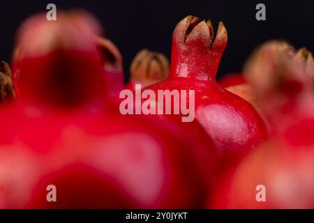 Un piccolo melograno rosso maturo è sdraiato sul tavolo, un frutto di melograno rosso maturo con grossi chicchi dolci Foto Stock