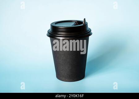 Tazza da caffè di carta nera su sfondo blu. Spazio vuoto per testo e design su una tazza di caffè. Il modulo per il nome del caffè o della società o della cof Foto Stock