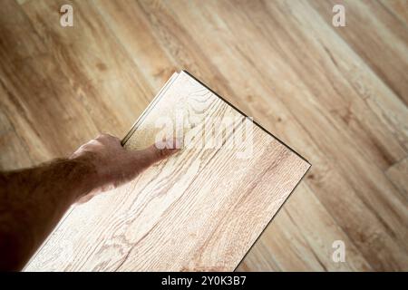 Pavimento in parquet laminato in legno, scelta di colori con vista dall'alto. Parquet in mano al maestro. Foto Stock