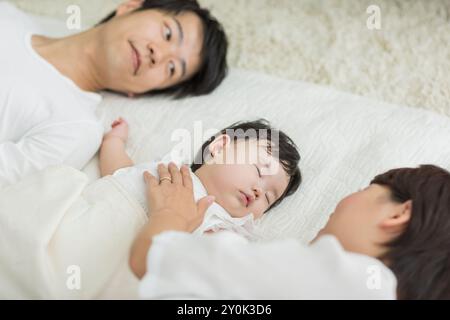 Genitori che guardano un bambino che dorme Foto Stock