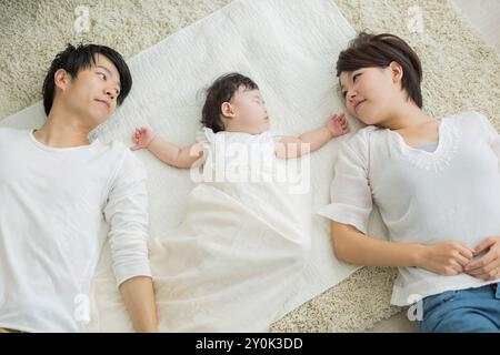 Genitori che guardano un bambino che dorme Foto Stock