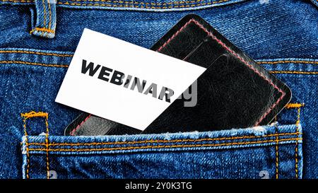 Parole DEL WEBINAR scritte su un biglietto da visita che sbuca fuori da un portabandiera in una tasca di jeans Foto Stock