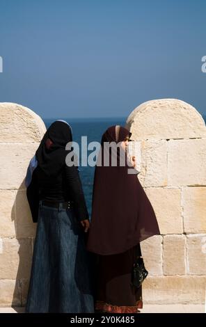 Giovani donne egiziane che si godono le vies del Mar Mediterraneo da Fort Qaitbey ad Alessandria, in Egitto. Foto Stock