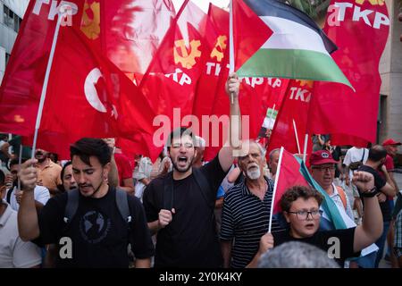 I membri del Partito Comunista di Turchia (TKP) marciano con bandiere palestinesi e di partito durante la manifestazione. I membri del Partito Comunista di Turchia (TKP) marciarono fino al porto di Izmir Alsancak dopo che la USS Wasp, una nave d'assalto anfibia inviata nella regione dagli Stati Uniti per proteggere Israele, attraccò al porto di Izmir Alsancak. La manifestazione contro la guerra è stata organizzata per sostenere il popolo palestinese e il Medio Oriente. È stato riferito che una veglia sarà tenuta di fronte al porto fino a quando la nave non partirà da Smirne. (Foto di Murat Kocabas/SOPA Images/Sipa USA) Foto Stock