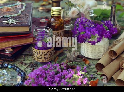 Mystic Still Life con magici libri di incantesimi, bottiglie e oggetti rituali strepitosi su un vecchio tavolo. Concetto occulto, esoterico, wicca e divinazione. Niente foreig Foto Stock