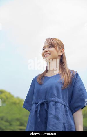 Il cielo blu e una donna giapponese sorridente Foto Stock