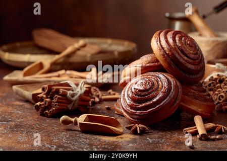 Panini alla cannella con ingredienti su un tavolo da cucina marrone. Foto Stock