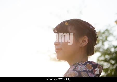 Profilo di donna in kimono crogiolata al sole del pomeriggio Foto Stock