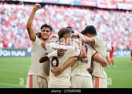 MONACO DI BAVIERA, GERMANIA - 01 SETTEMBRE: Harry Kane del Bayern Muenchen celebra il gol 1:0 con Aleksandar Pavlovic del Bayern Muenchen e Joshua Kimmich del Bayern Muenchen durante la partita di Bundesliga tra il Bayern München e lo Sport-Club Freiburg all'Allianz Arena il 1 settembre 2024 a Monaco di Baviera, Germania. © diebilderwelt / Alamy Stock Foto Stock