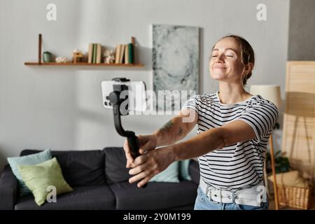 Una giovane donna con vitiligine sorride brillantemente mentre scatta un selfie in casa. Foto Stock