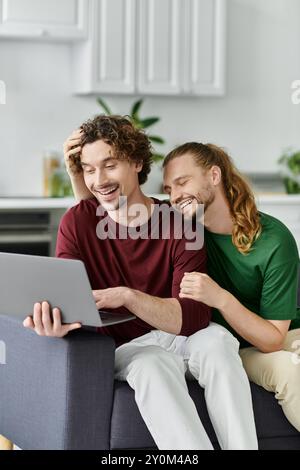 Una coppia felice condivide un momento di tenerezza mentre lavora su un notebook. Foto Stock