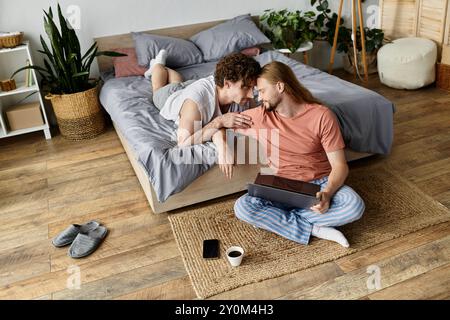 Una coppia condivide un momento tenero rilassandosi nella loro accogliente camera da letto. Foto Stock