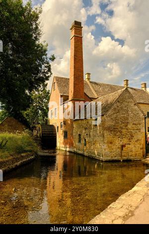 Lower Slaughter Museum e ruota idraulica lungo il pittoresco River Eye a Bourton on the Water, Cotswolds, Gloucestershire, Inghilterra, Regno Unito Foto Stock