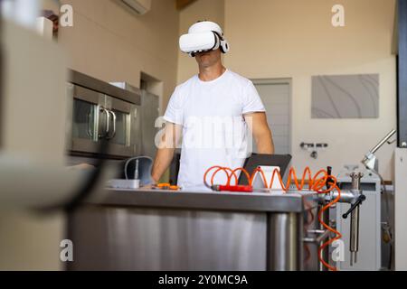 Utilizzando il visore VR, uomo che lavora in un laboratorio protesico con strumenti sul tavolo Foto Stock