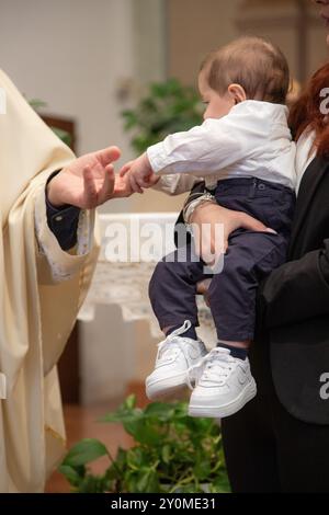 Celebrazione del battesimo in chiesa, sacerdote e bambino Foto Stock