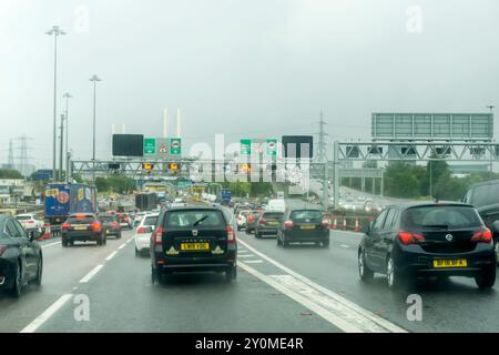 Traffico intenso sull'autostrada M25 che si avvicina all'ingresso sud del Dartford Tunnel durante la pioggia. Foto Stock