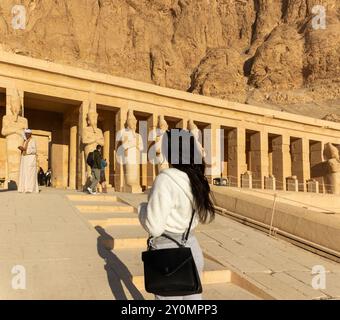 Luxor, Egitto; 16 gennaio 2024: Donna che visita il tempio di Hatshepsut, conoscendo e contemplando i misteri di questo faraone e dell'aldilà Foto Stock