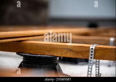 Vista ravvicinata ad angolo basso di una costruzione di fondamenta in legno per un nuovo patio esterno in tavole di legno. Lavori di ristrutturazione e costruzione Foto Stock