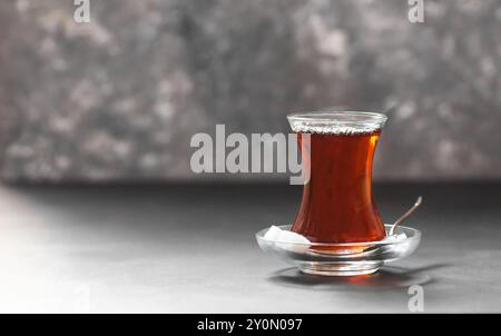 Tazza in vetro di tè turco nero estratto da teiera, tradizionale concetto di bevanda calda Foto Stock