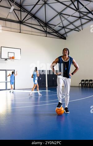 Giocare a basket, uomo afroamericano mentre giocano in palestra, copiare lo spazio Foto Stock