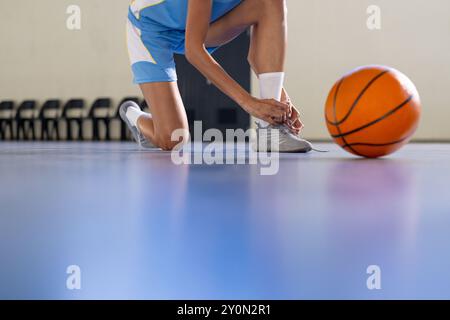 Allacciare lacci scarpe, giocare a pallacanestro in preparazione per la partita sul campo, copiare spazio Foto Stock