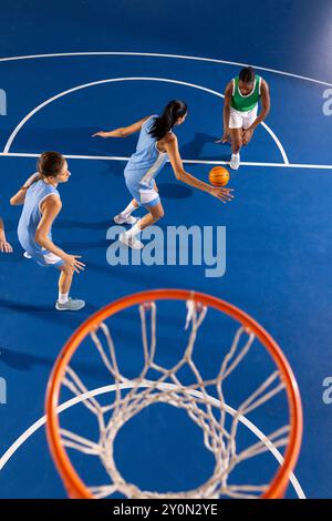 Giocando a basket, giocando a dribbling e difendendosi su un campo coperto Foto Stock