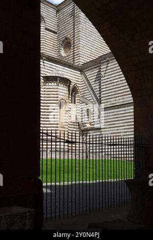 Pareti laterali del Duomo di Orvieto con strati alternati di pietra bianca e nera Foto Stock