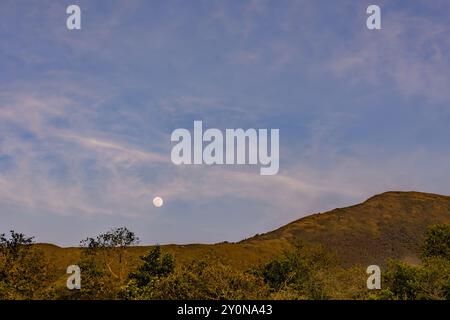 La luna quasi piena sorge sul monte Iguaque, nelle Ande orientali della Colombia centrale, su un cielo limpido e fatato al tramonto. Foto Stock