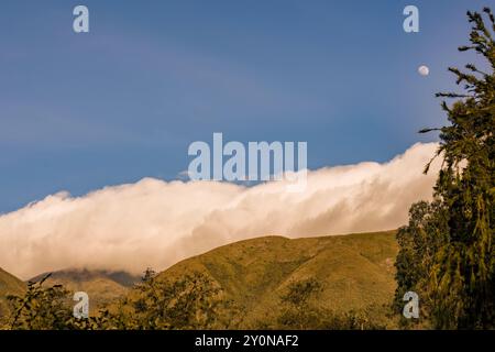 La luna quasi piena sorge sul monte Iguaque, nelle Ande orientali della Colombia centrale, su un cielo limpido e fatato al tramonto. Foto Stock