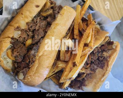 Cheesesteak, panini e patatine fritte su tavolo in legno da Diners Perspective Foto Stock