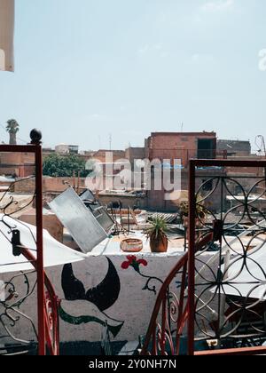 Una giornata di sole a Marrakech rivela una colorata vista sul tetto piena di piatti satellitari, un arredamento eclettico e il fascino dell'architettura locale a fronte di un Foto Stock