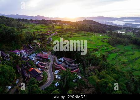 Alba sullo spettacolare paesaggio dell'area di Batutumonga a Tana Toraja a Sulawesi, strada che passa per un villaggio, risaie, foresta, montagne, Indonesia Foto Stock