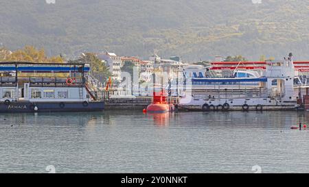 Ohrid, Macedonia del Nord - 23 ottobre 2023: Nave sottomarina rossa ormeggiata e barche turistiche presso Marina Port Lake Ohrid Autumn Day. Foto Stock