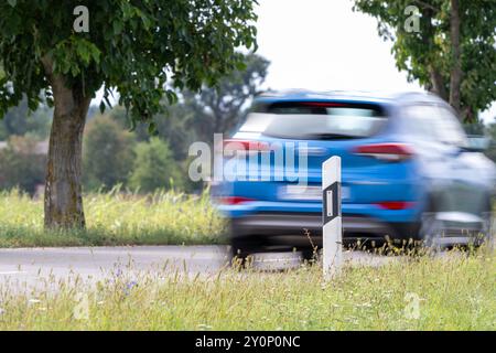 , Deutschland, 03.09.2024, Auf einer Landstraße fahren Autos an einem Leitpfosten vorbei. DAS Bild zeigt die Dynamik des Straßenverkehrs in einer län Foto Stock