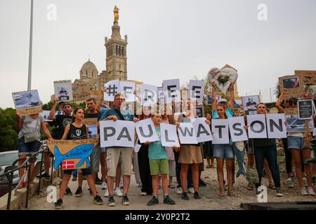 I manifestanti hanno dei cartelli con scritto "Free Paul Watson" durante la dimostrazione. I manifestanti si sono riuniti fuori dalla basilica di Notre-Dame de la Garde a Marsiglia per sostenere il capitano Paul Watson, fondatore dell'organizzazione ambientale Sea Shepherd. Il capitano Paul Watson è stato arrestato in Groenlandia il 21 luglio dalla polizia danese su richiesta del Giappone, che lo accusa di complicità nell'aggressione e nella violazione di una nave, che lo ha visto affrontare fino a 15 anni di carcere. Le autorità giapponesi hanno richiesto la sua estradizione. Foto Stock