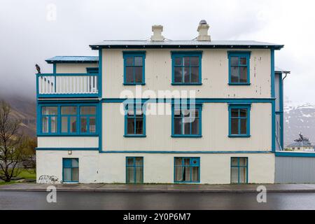 Tradizionale edificio residenziale islandese bianco con cornici blu per finestre, rivestite in lamiere ondulate nella città di Seydisfjordur in Islanda. Foto Stock